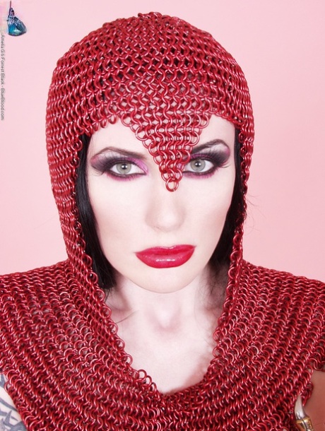 Busty chick Morrigan Hel licks a dagger while wearing chain mail and OTK boots 86240246