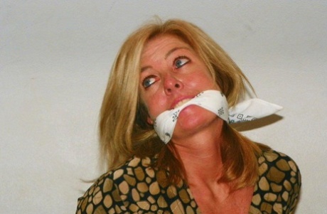Blond female struggles on a bed while gagged and blindfolded 10859590
