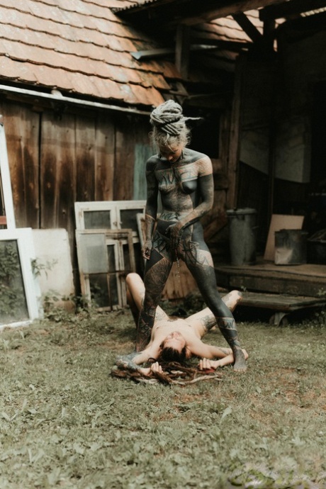 Heavily tattooed girls piss on a naked man outside the back steps of a house 59105543